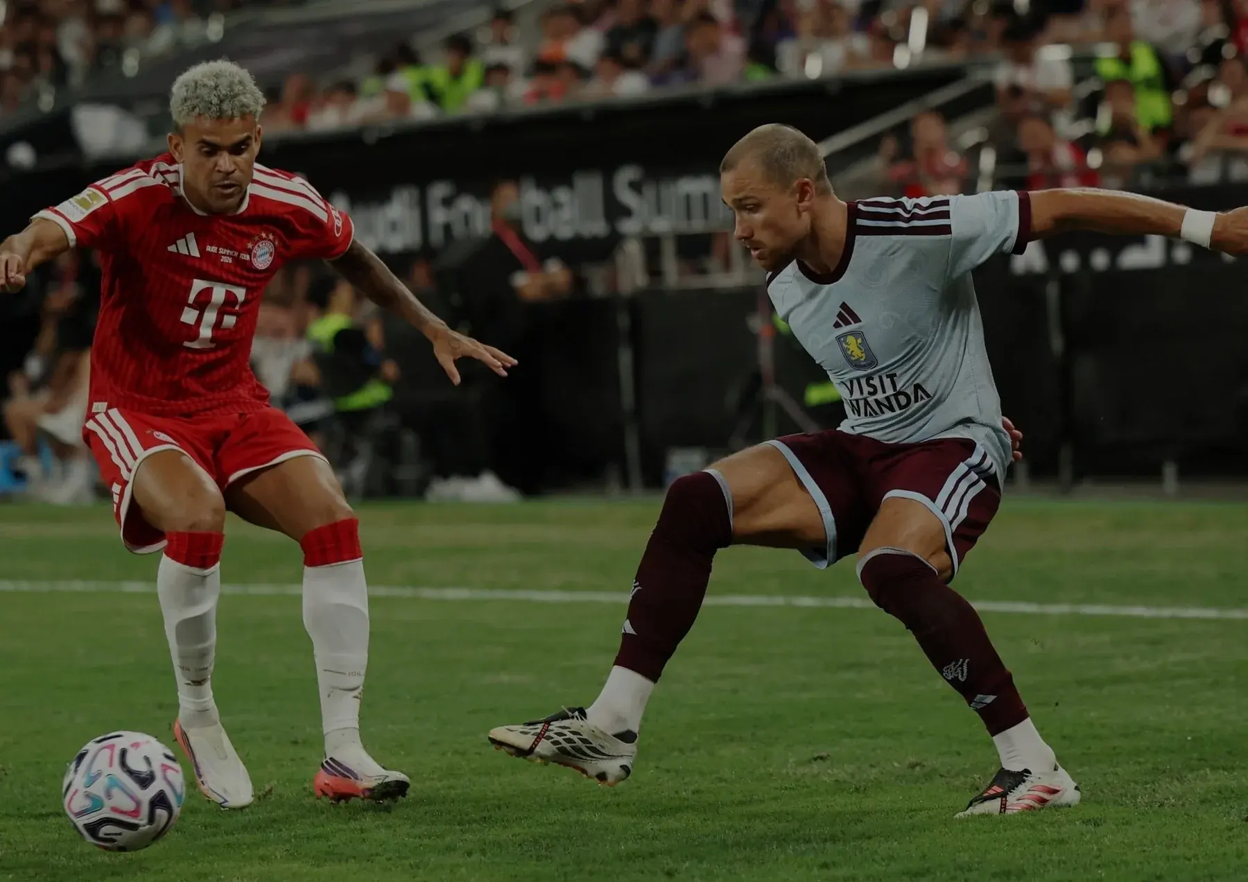 FC Bayern Munich and Aston Villa players contesting the ball during Audi Football Summit 2026.